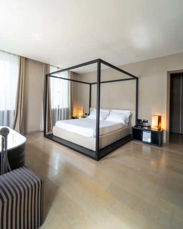 👑 La Stanza del Vescovo: dove l'antico incontra l'eternoAl secondo piano dell'Hotel San Rocco, la Junior Suite "Stanza del Vescovo" custodisce un'atmosfera rarefatta e austera. Il letto a baldacchino firmato Antonio Citterio, pezzo unico al mondo insieme a quello del Bulgari di Milano, domina la camera con eleganza contemporanea. Ma il vero capolavoro è la vasca a tinozza che si affaccia direttamente sul lago attraverso cinque grandi finestre: qui potete cenare al lume di candela o rigenerarvi in un bagno mentre l'Isola di San Giulio veglia sui vostri sogni.Un luogo dove storia, spiritualità e design si fondono in perfetta armonia ✨📍 Hotel San Rocco – Lago d'Orta📞 Info: +39 0322 911977✉️ info@hotelsanrocco.it🌐 www.hotelsanrocco.it👑 The Bishop's Room: where ancient meets eternalOn the second floor of Hotel San Rocco, the "Bishop's Room" Junior Suite preserves a rarefied and austere atmosphere. The four-poster bed by Antonio Citterio, unique piece in the world together with the one at Bulgari Milan, dominates the room with contemporary elegance. But the real masterpiece is the tub that faces directly onto the lake through five large windows: here you can dine by candlelight or regenerate in a bath while San Giulio Island watches over your dreams.A place where history, spirituality and design merge in perfect harmony ✨📍 Hotel San Rocco – Lake Orta📞 Info: +39 0322 911977✉️ info@hotelsanrocco.it🌐 www.hotelsanrocco.it#StanzaDelVescovo #JuniorSuite #AntonioCitterio #LagoDOrta #LuxuryDesign #IsolaDiSanGiulio #UniqueExperience #DesignHotel